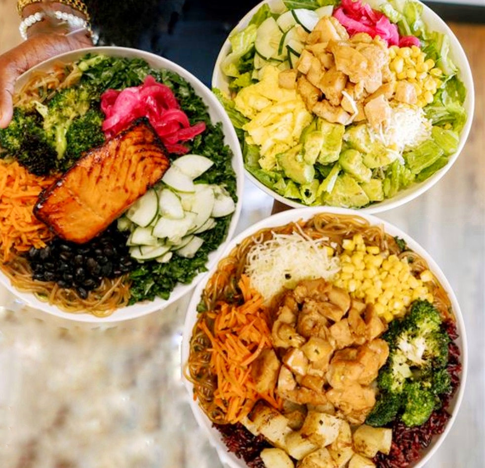 Three bowls of colorful salads with various ingredients on a blurred background